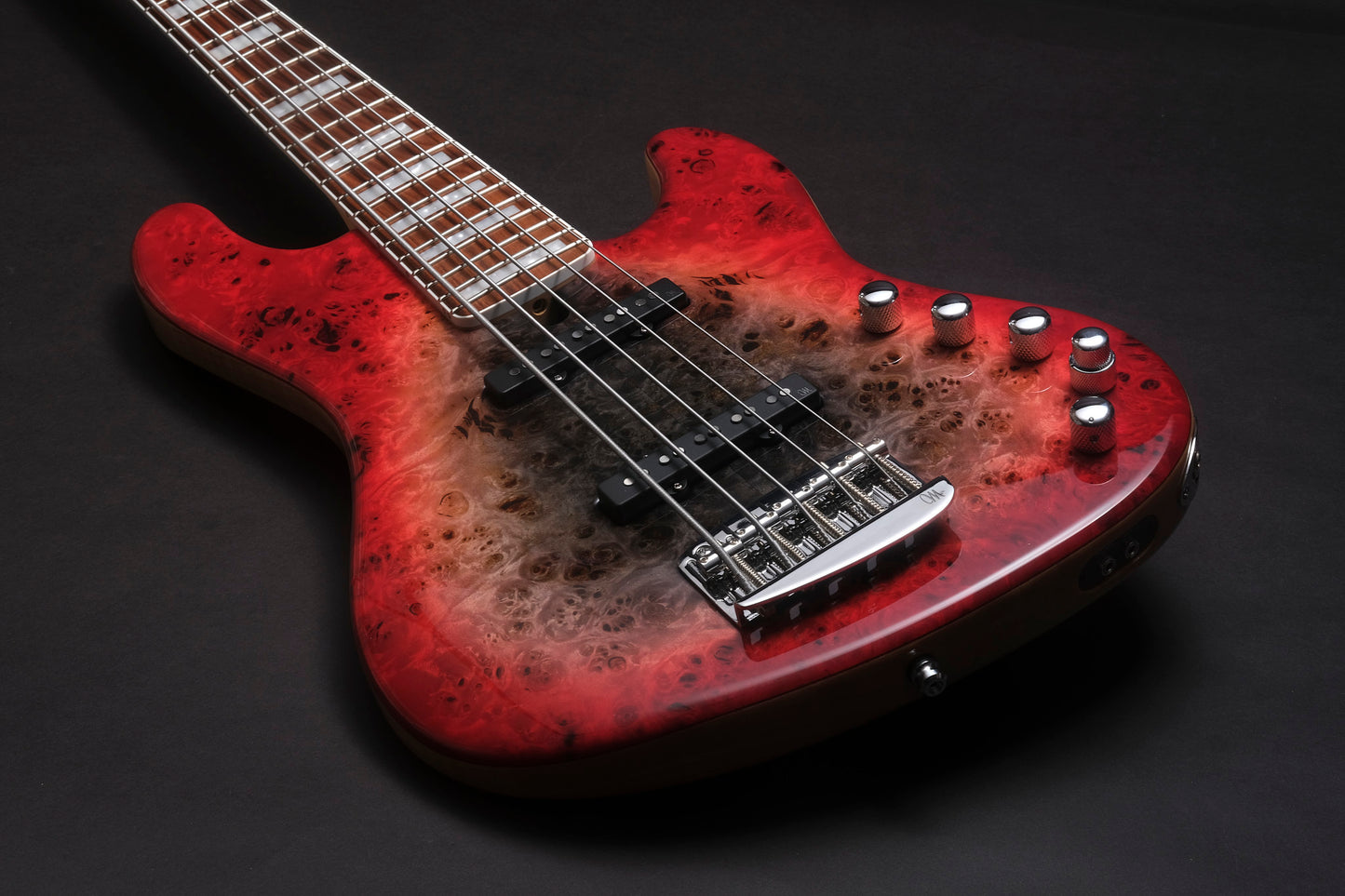 Red electric bass guitar with a worn finish on a black background
