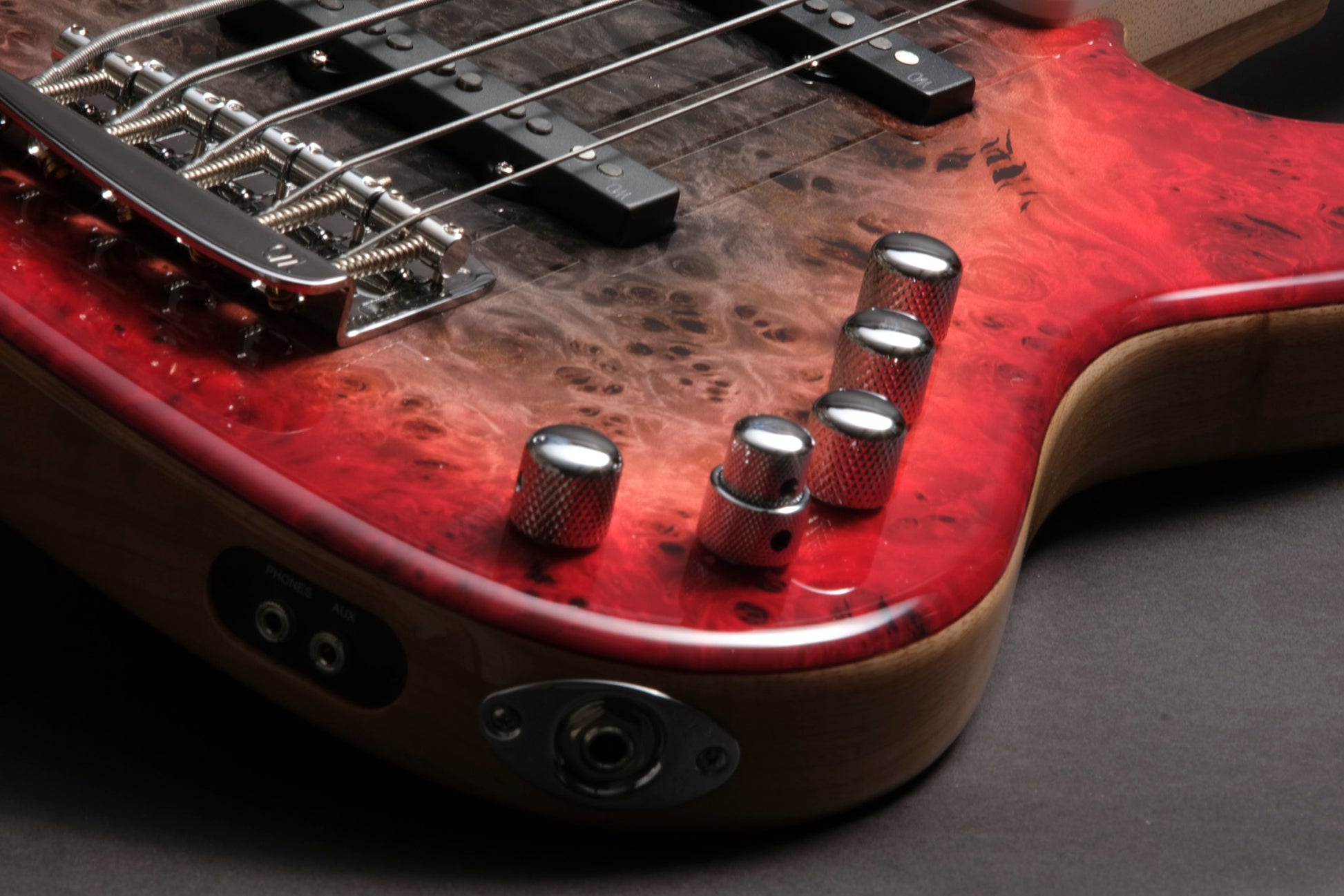 Close-up of a red electric guitar with visible wear and strings.
