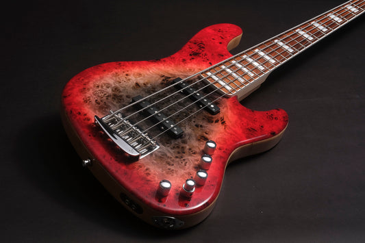 Red electric bass guitar with a worn finish on a black background