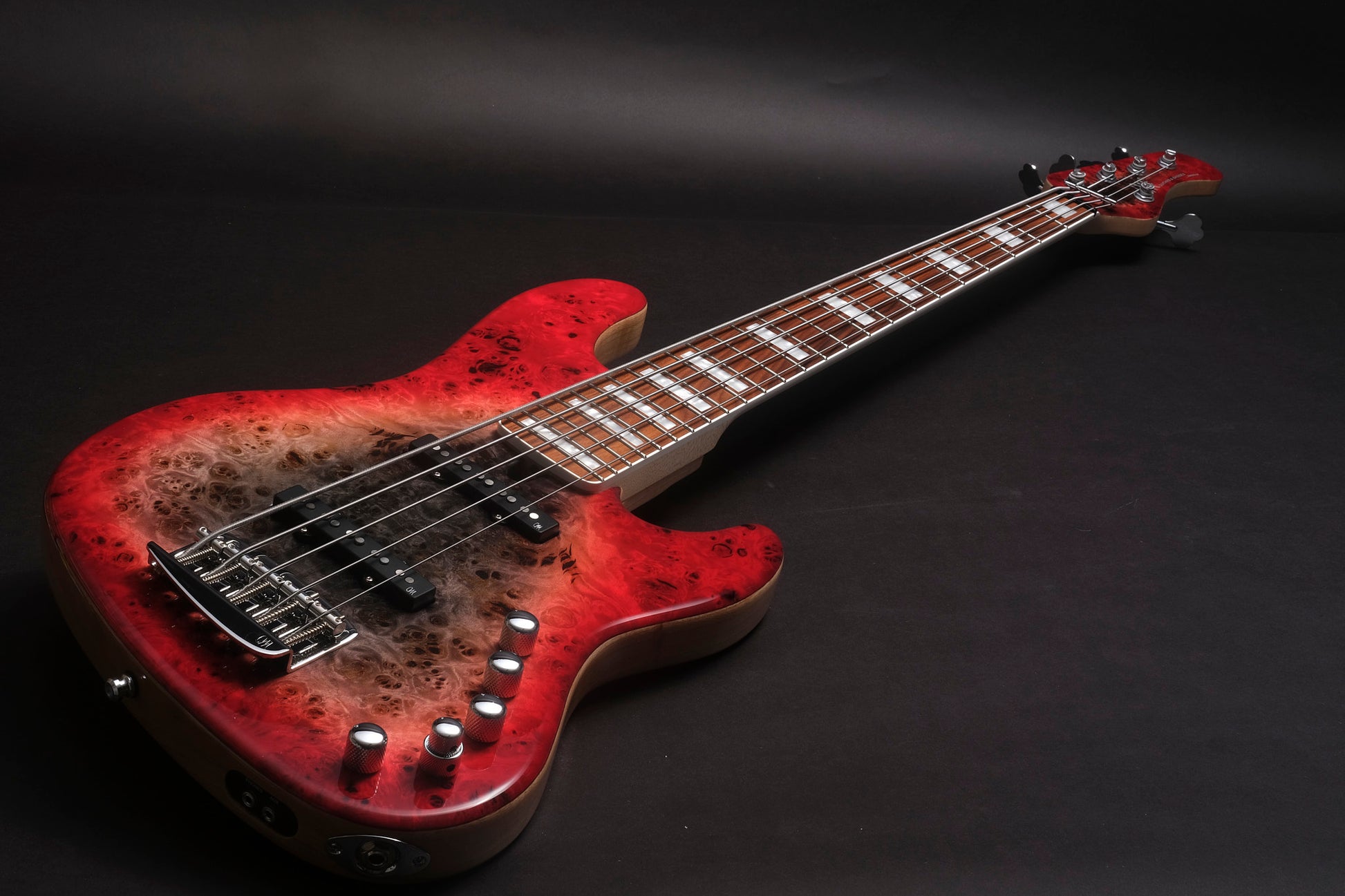 Red electric bass guitar with a worn finish on a black background